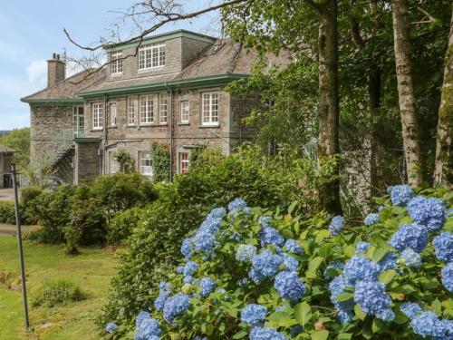 an old house with blue flowers in front of it at Sethera in Ambleside