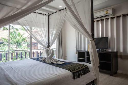 a bedroom with a canopy bed with a large window at Poonsiri Private Pool Villa Aonang in Ao Nang Beach
