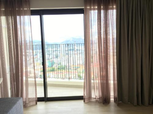 a room with a large window with a view at Gold Coast Luxury Apartment Nha Trang in Nha Trang