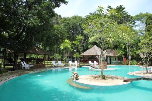 una piscina en un complejo con un perro en el agua en Villa Cha Cha Chaolao Beach Resort, en Chao Lao Beach