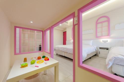 a bedroom with two beds and a table in a room at The Lin Inn in Kenting