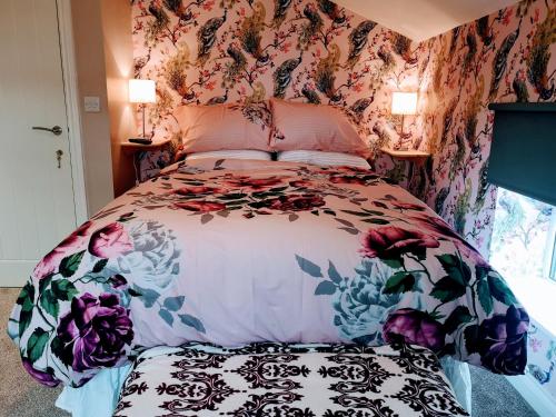 una camera da letto con un letto con carta da parati floreale di Brampton Dales Farm a Gainsborough