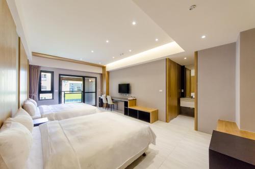 a bedroom with a large bed and a desk at The Lin Inn in Kenting
