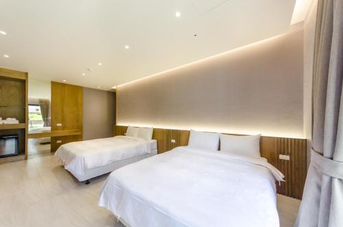 a hotel room with two beds and a television at The Lin Inn in Kenting
