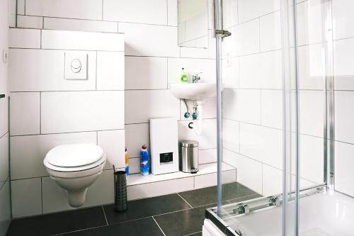 a bathroom with a toilet and a sink and a tub at Pension & Monteurwohnungen Burglesum Bremen in Bremen