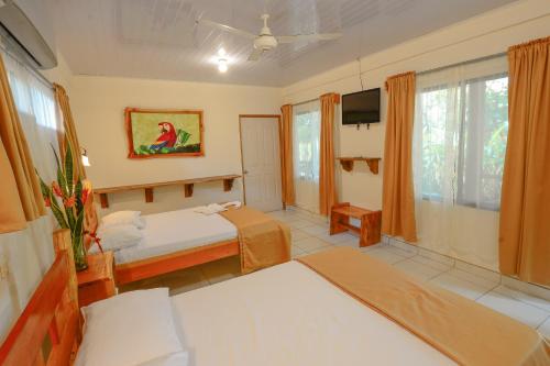 a bedroom with a bed and a tv in a room at Hotel Cerro Lodge in Tarcoles