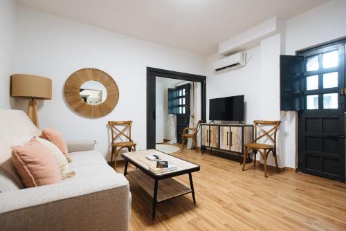 salon z kanapą i telewizorem w obiekcie Aitana's Retreat with charming garden w Sewilli