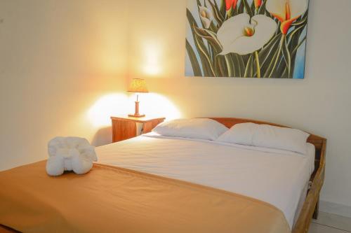 a bedroom with a bed with a stuffed animal on it at Hotel Cerro Lodge in Tarcoles