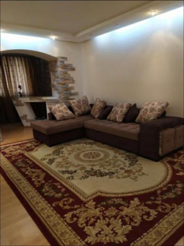 uma sala de estar com um sofá e um tapete em Апартаменты Koonjak em Tashkent