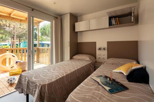 two beds in a room with a balcony at Residence Punta Spin in Grado