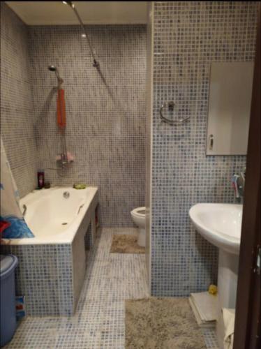 uma casa de banho com uma banheira, um lavatório e um WC. em Апартаменты Koonjak em Tashkent