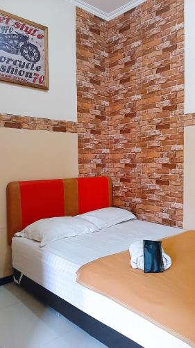 two beds in a room with a brick wall at Omah Wetan Homestay in Malang