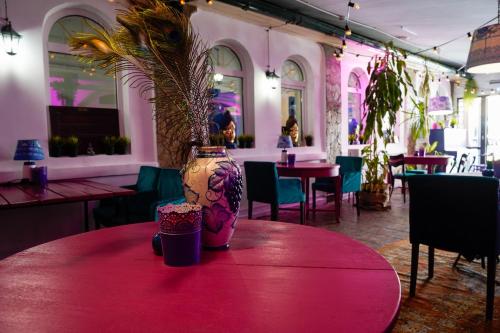モスクワにあるSkazka Asia Design Hotel in Izmailovo Kremlinの花瓶付きピンクのテーブル