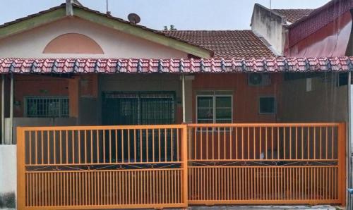 クアラ・カンサーにあるHomestay Ummi Razzinの前にオレンジの柵がある家