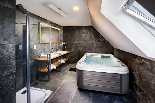 a bathroom with a bath tub and a sink at Rezort Maladinovo pri Liptovskej Mare in Liptovský Mikuláš