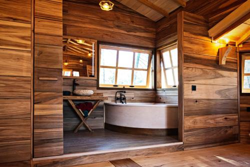 a bathroom with a tub and wooden walls at Cabañas Rurales Los Barrancos in Villalba de la Sierra