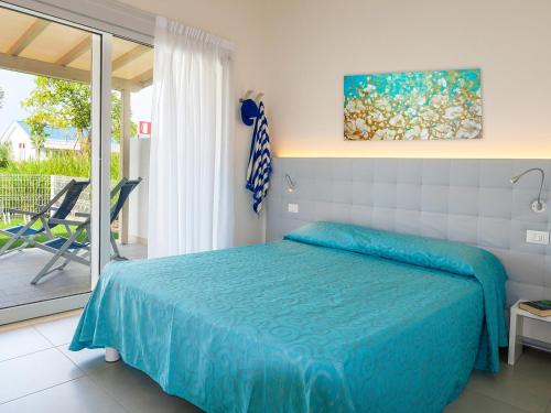 a bedroom with a blue bed and a balcony at Portofelice Camping Village in Eraclea Mare