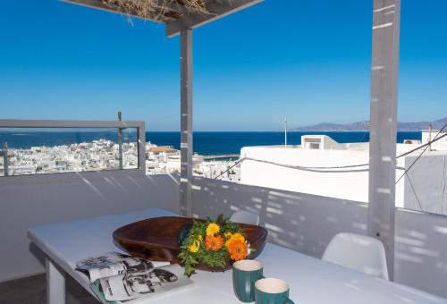 a table topped with a bowl of fruit on top of a beach at Madres Houses in Mikonos