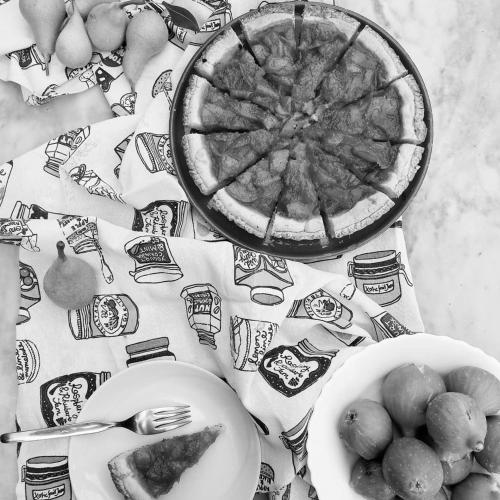 a table with a plate of pizza and a bowl of fruit at Idria B&B in Barcellona-Pozzo di Gotto