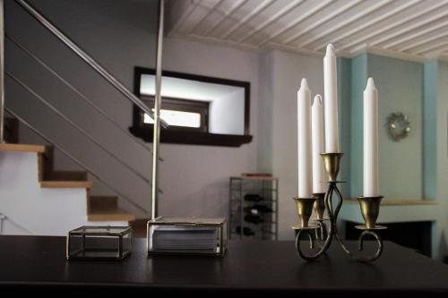 a table with two candles on it with a staircase at Tsarbou Guesthouse in Stemnitsa