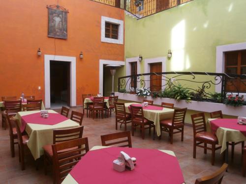 a dining area with tables and chairs and umbrellas at Hotel Anber in Dolores Hidalgo
