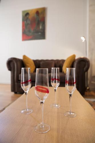 quatre verres à vin assis au-dessus d'une table en bois dans l'établissement Spacieux appartement, A-mi-chemin, au coeur de Tournus, à Tournus
