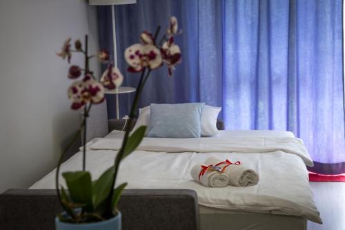 a bedroom with a bed with white sheets and flowers at Dream Apartment in Suwałki