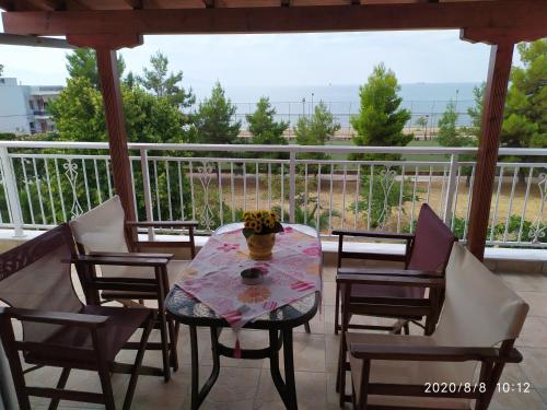 a table and chairs on a porch with a view at Aegean View Seaside Apartment in Kavala