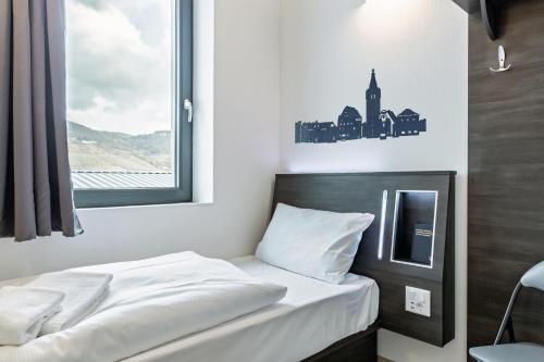 a small bedroom with a bed with a window at Augustus Hotel Bernkastel - Comfortable Budget Hotel in Bernkastel-Kues