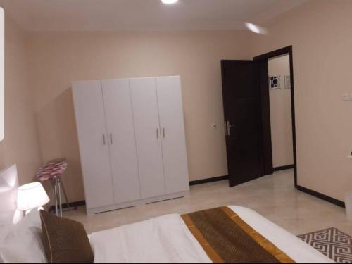 a bedroom with a large white cabinet and a door at أجنحة ريحانا in Tabuk