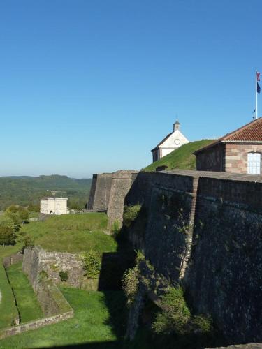 an old stone wall with a house on a hill at Le Relais Des Chateaux Forts in Bitche
