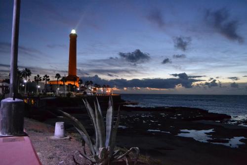 a lighthouse on a pier with the ocean at night at Brasilia in Chipiona