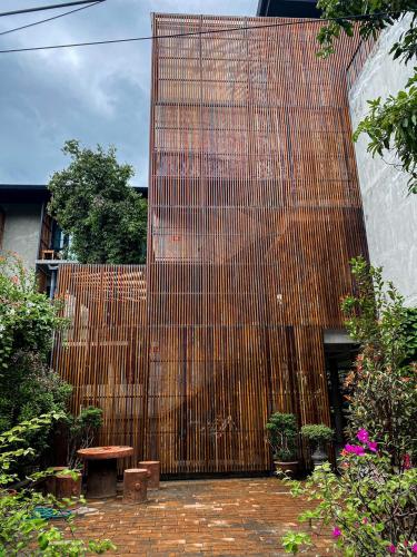 a wooden fence in front of a building with a table at Lamphu House Chiang Mai in Chiang Mai