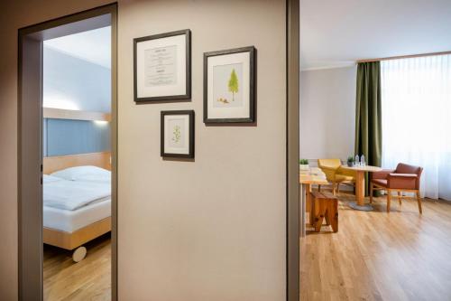 Una puerta que conduce a un dormitorio con cama y mesa. en JUFA Hotel Waldviertel, en Raabs an der Thaya