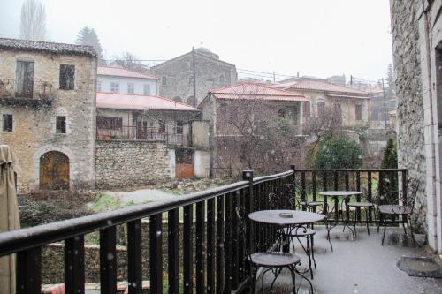 a balcony with tables and chairs in the snow at Tsarbou Guesthouse in Stemnitsa