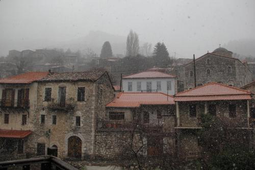 a city in the snow with houses and buildings at Tsarbou Guesthouse in Stemnitsa