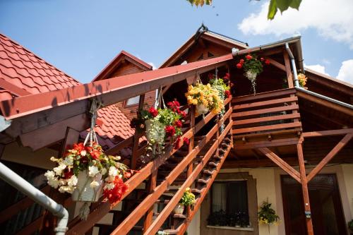 a house with flowers on the stairs of it at Pensiune Saroklak in Sîncraiu