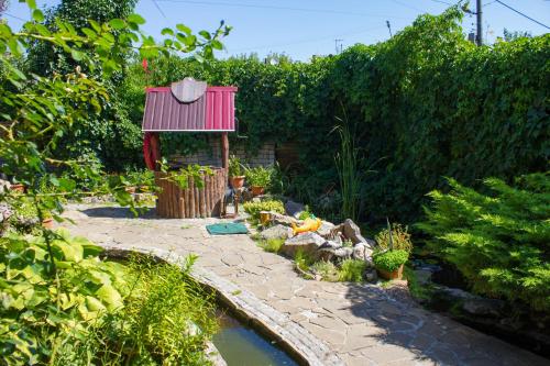 un jardín con un estanque y un techo rojo en КЛУБ B55 en Dnipró
