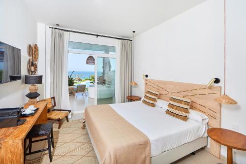 a hotel room with a bed and a desk and a bedroom at FERGUS Conil Park in Conil de la Frontera