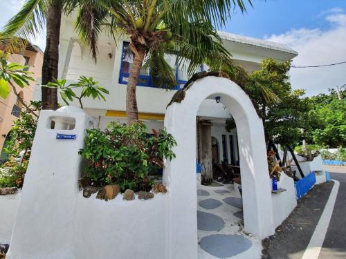 a white house with palm trees in front of it at 墾丁愛情海民宿 in Kenting
