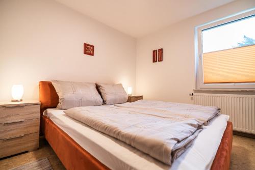 a bedroom with a large bed and a window at Ferienwohnung im Ottenhai (EG) in Bad Harzburg