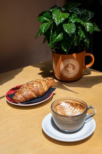 a cup of coffee and croissants on a table with a plant at Vico d'Ercole in Fondi