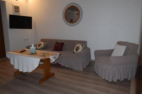 a living room with a couch and a table and a chair at Casa di levante - Glossa Skopelos in Loutraki