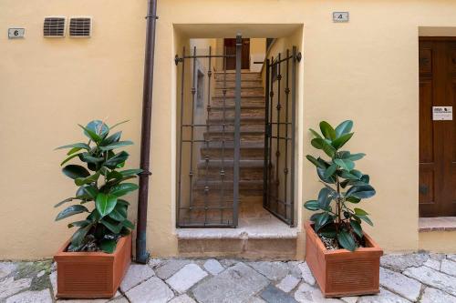 two potted plants in front of a building with a staircase at Vico d'Ercole in Fondi