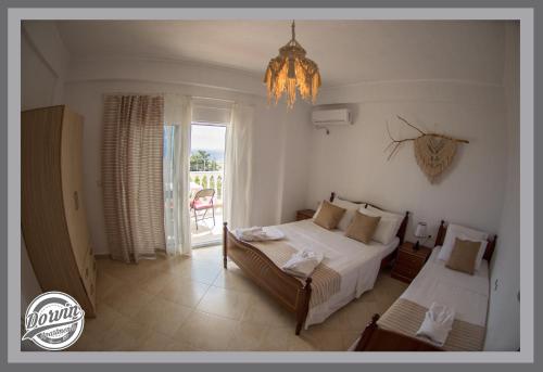 a bedroom with two beds and a chandelier at Dorvin Apartments in Dhërmi