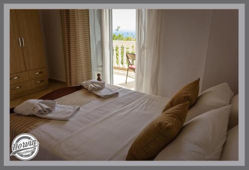 a bedroom with a large bed with towels and a window at Dorvin Apartments in Dhërmi