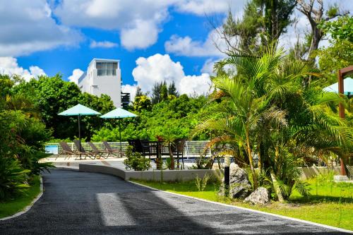 a street with trees and umbrellas and a building at Odysis Onna Resort Hotel in Onna