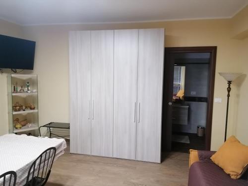 a bedroom with a white cabinet and a couch at Agave in Reggio Calabria