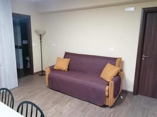 a purple couch in a living room with chairs at Agave in Reggio Calabria