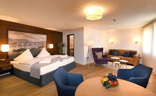 ein Hotelzimmer mit einem Bett, einem Tisch und Stühlen in der Unterkunft Hotel & Weinhaus Anker in Marktheidenfeld
